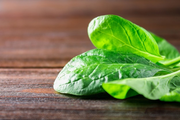 Green fresh spinach leaves on a wooden table