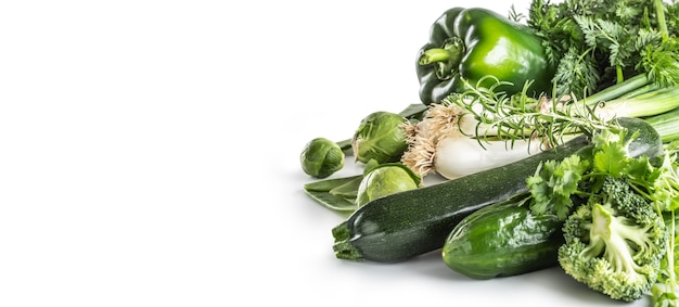 Green fresh vegetable isolated on white background. Onion cucumber peas broccoli zucchini and other healthy vegetables.