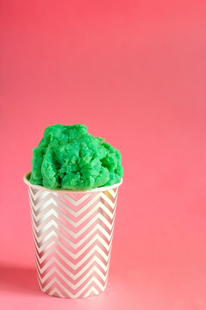 Green fruit ice cream or frozen yogurt in stripped cup 