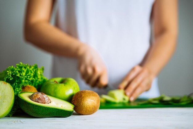 Foto frutta verde sulla parte anteriore donna frutta tagliata sullo sfondo sana f