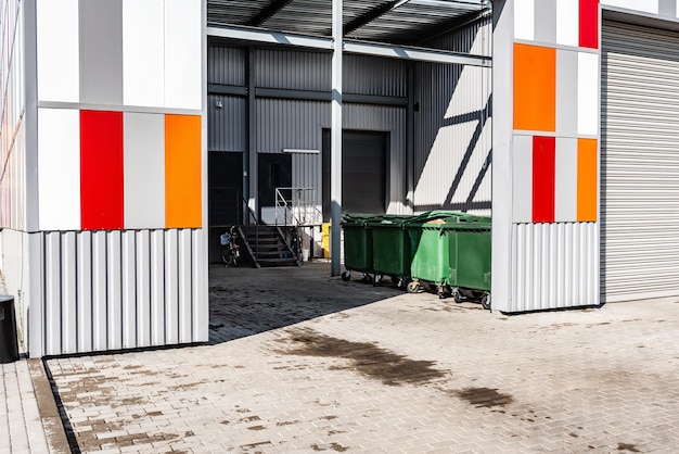 Green garbage containers on backyard of store.