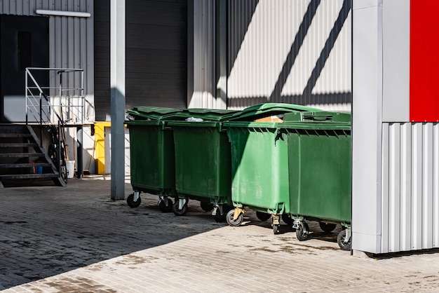 Foto contenitori di immondizia verdi sul cortile del negozio.