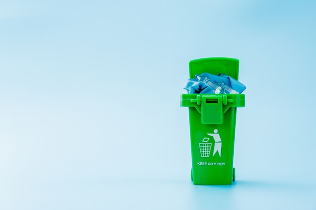 Photo green garbage, trash bin on blue background