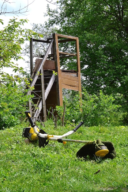 In the green garden there is a summer shower on a lying lawnmower