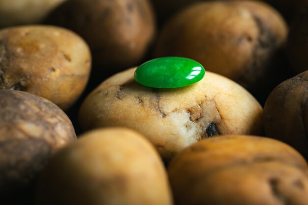 The green gem on river gravel background.Close-up,old gemstone ,nature jewelry