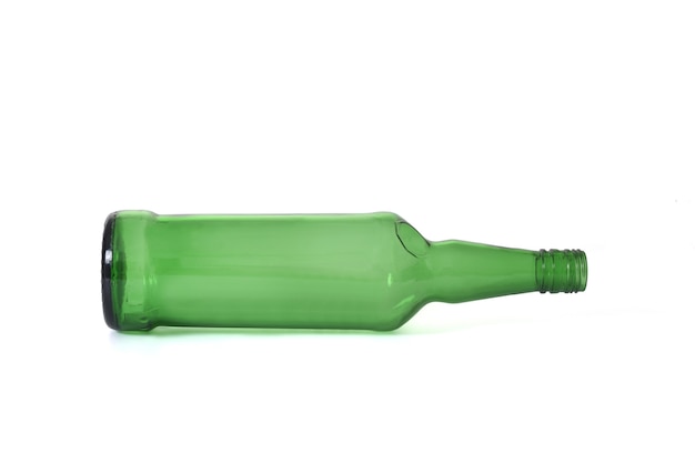 Foto bottiglia di vetro verde di whisky sdraiata su sfondo bianco