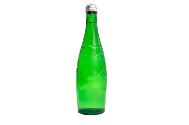 Фото Зеленая стеклянная бутылка с водой на белом фоне. минеральная вода в стеклянной бутылке с.