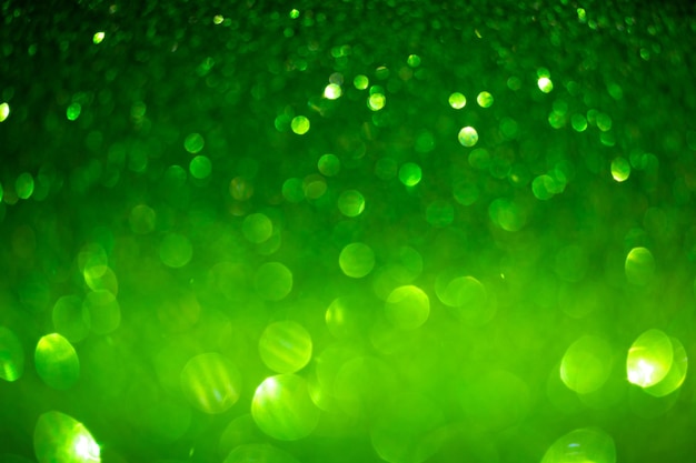 Photo green glittering background. christmas sparkles, texture with bokeh and shiny lights photo