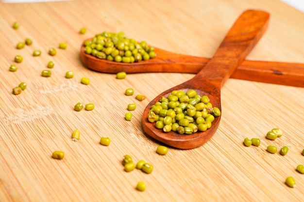 Green gram or mung bean in wooden spoon over wooden background.