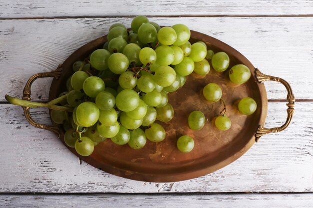 Green grape on tray on wooden background