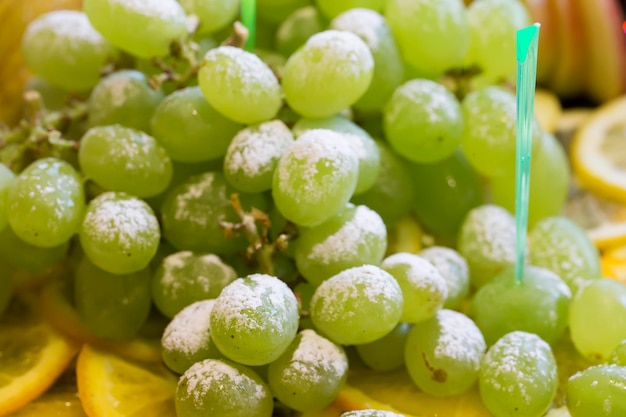 Photo green grapes with powdered sugar fruit dessert