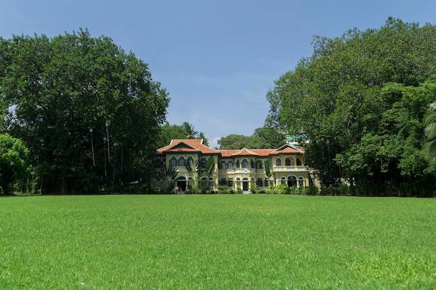 green grass building blue sky and trees