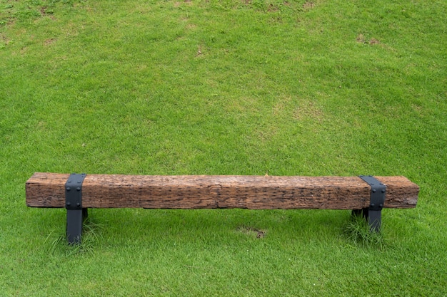 Green grass field with old wooden bench