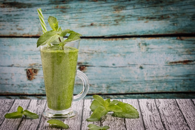 Frullato di erba verde in un bicchiere sul tavolo