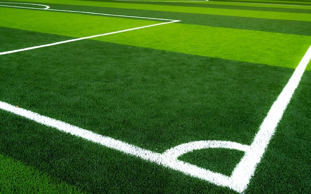 Green grass soccer field. Empty artificial turf football field with white line. 