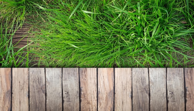 Photo green grass with old rustic wooden floor top view