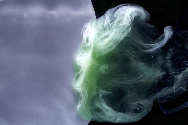 Green gray smoke on black ink background colorful fog abstract swirling touch ocean sea acrylic paint pigment underwater