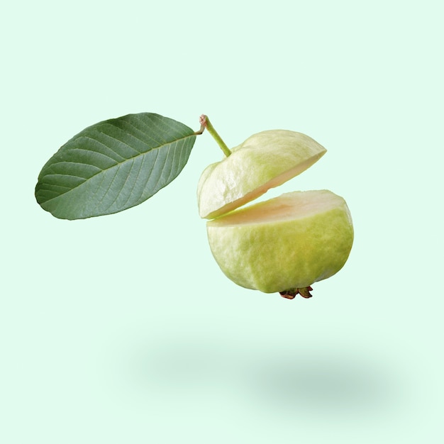 Guava verde che vola su uno sfondo blu idee creative per il cibo estivo le giovani noci di cocco galleggiano nell'aria