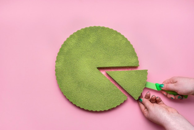 Green hand holding leaf against colored background