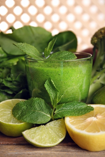 Foto succo verde sano con frutta ed erbe sulla tavola da vicino