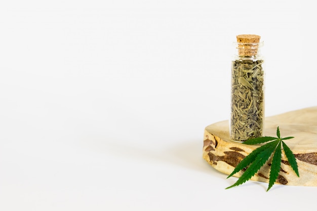 緑の麻の葉と瓶の中の乾燥葉