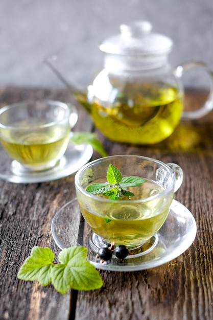  Green herbal tea with a berries in glass cup on wooden table