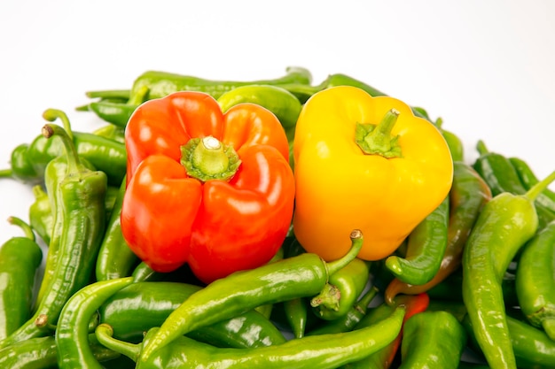 Зеленый острый перец и красный и желтый болгарский перец на белом фоне. витаминные овощи для здоровья