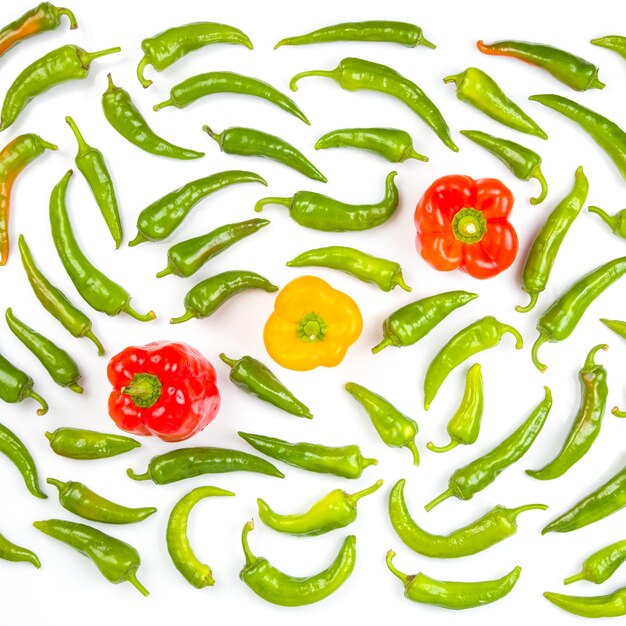 Green hot peppers and red and yellow bell peppers on a white background vitamin vegetables for health