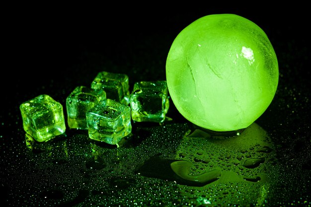 Green ice ball reflection on black background.