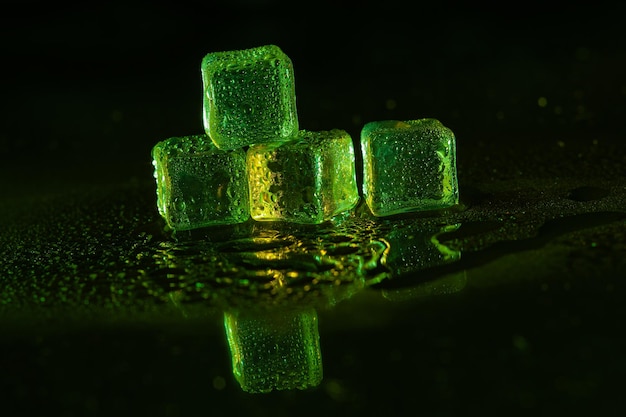 Green ice cubes on black background