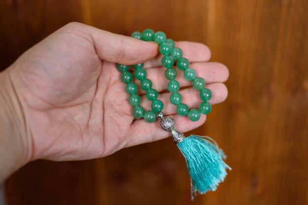 Photo green jade rosary in a man's hand