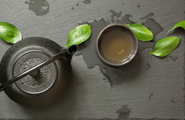 Green japanese tea with black teapot and bowl