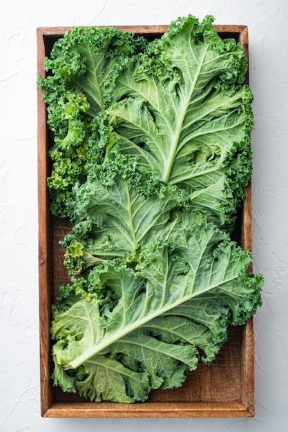 Green kale salad leaf set, in wooden box, on white, top view flat lay