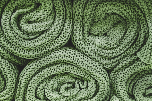 Green knitted blankets rolled into rolls