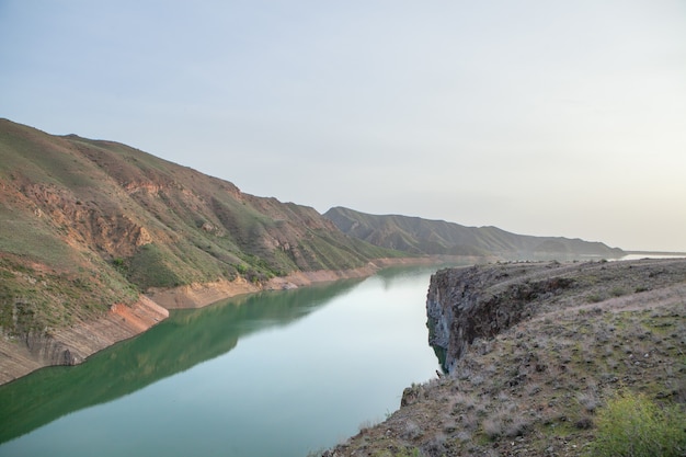 Green lake between mountains in the evening