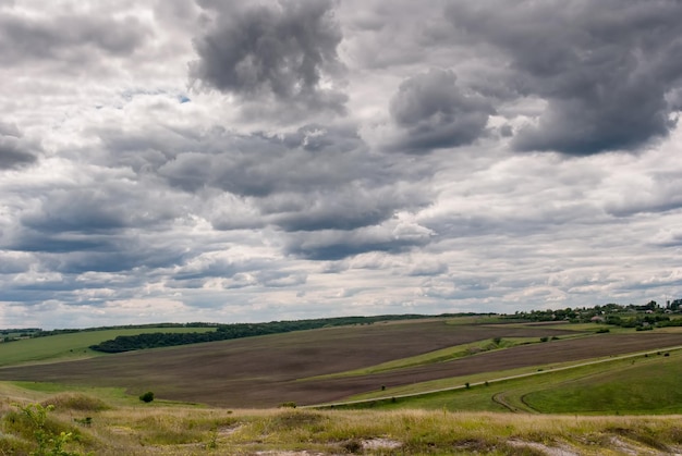 Foto paesaggio verde di terreni agricoli contro un cielo tempestoso nella stagione primaverile concetto di spazio pubblicitario