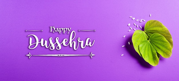 Green leaf and rice on purple pastel background Dussehra banner