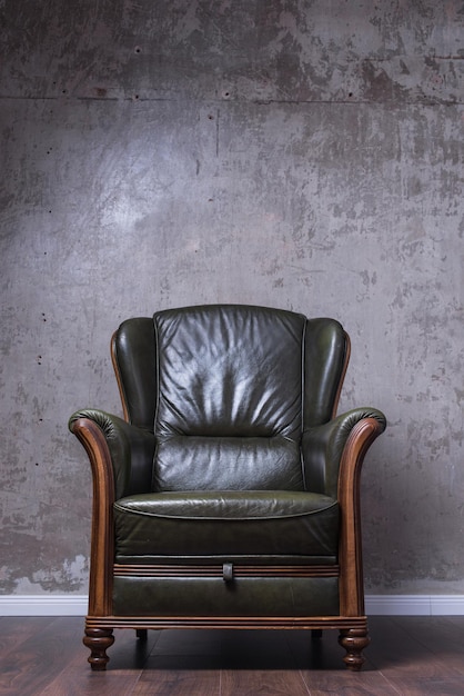 green leather armchair in front of the wall