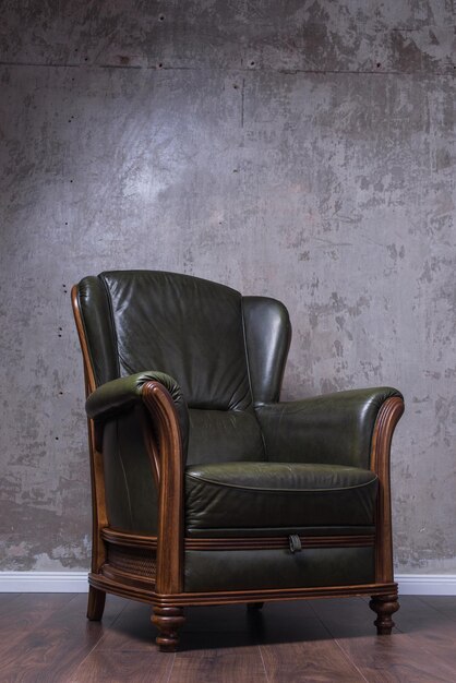 Green leather armchair in front of the wall