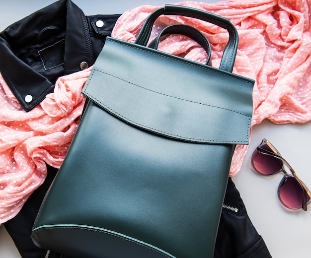 Green leather backpack with sunglasses