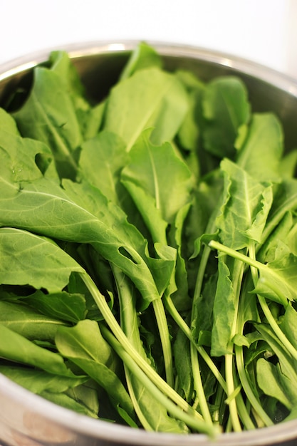 Green leaves of arugula in silver bowl