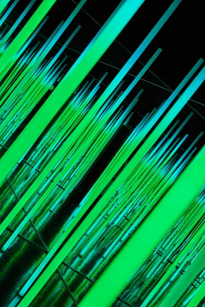 Green LED light poles at angle in abstract