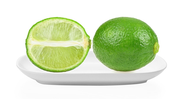 写真 白い背景の上の白いプレートの緑のレモン