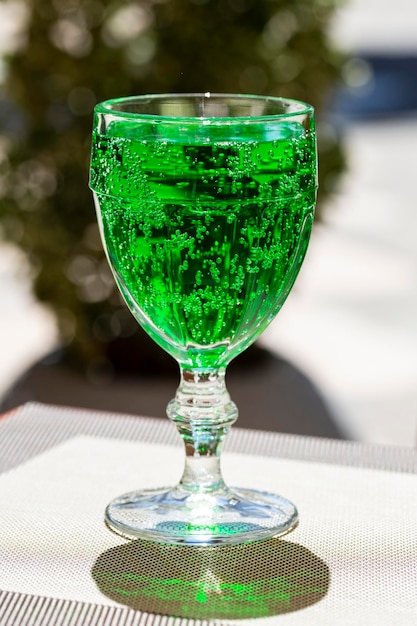 Green lemonade Tarragon in a glass glass on a blurry background closeup Green drink from healthy herbs Tarragon