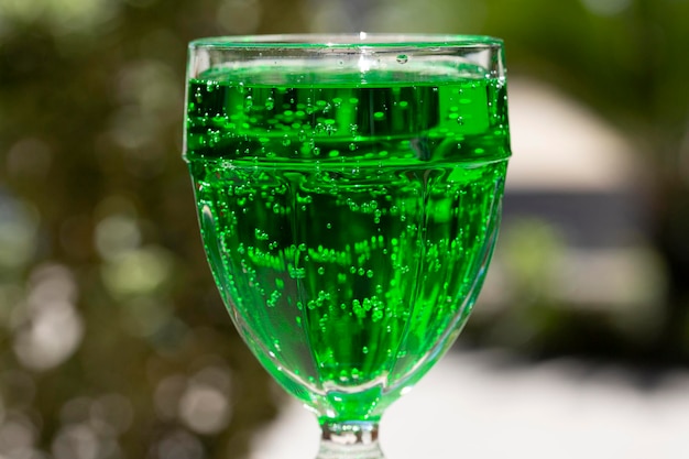 Green lemonade Tarragon in a glass glass on a blurry background closeup Green drink from healthy herbs Tarragon