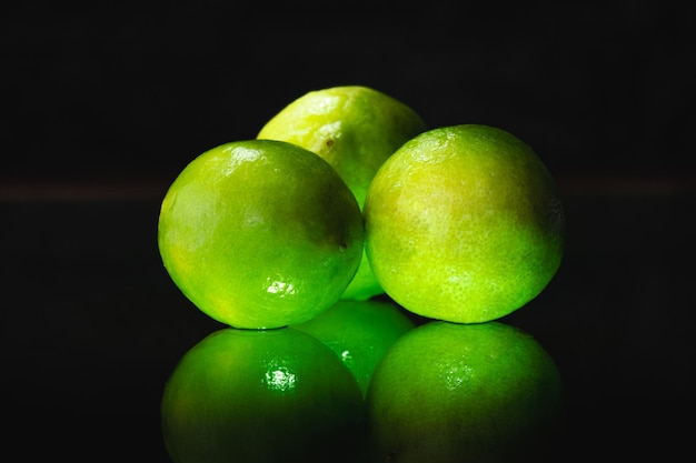 green lemons on black background