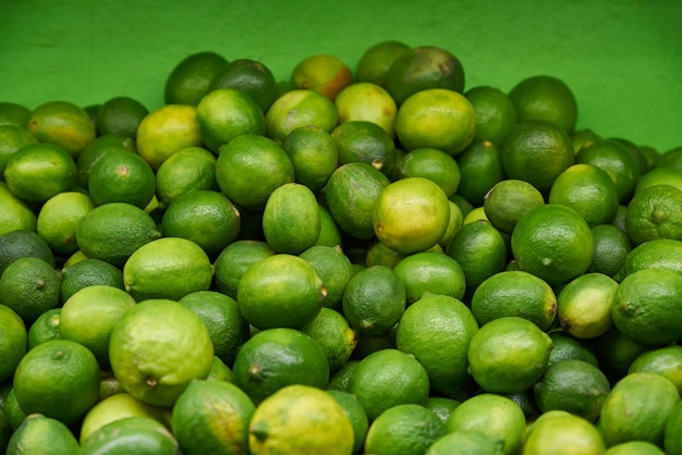 Green lemons placed on a shelf for sale at a market
