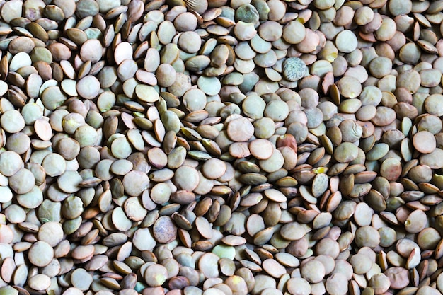 Green lentils, detail texture background, closeup of lentils background. High quality photo