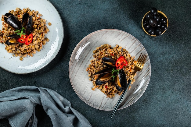 Green lentils with fried seafood and mussels in a dish on a slate background Healthy food