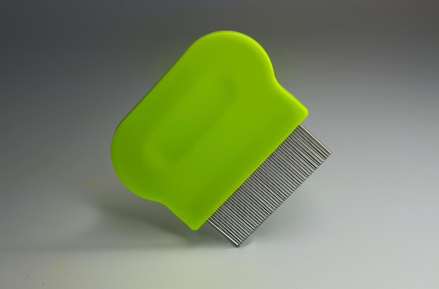 green lice comb floating isolated on a grey background